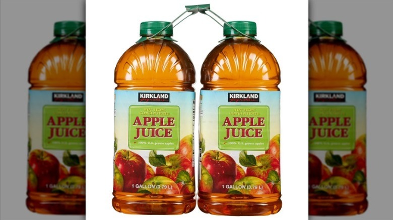 Two bottles of Kirkland apple juice on white background
