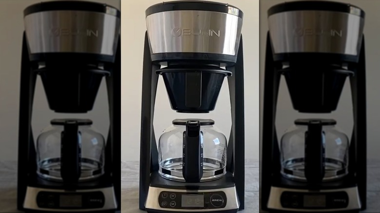 Pouring water over filter of drip coffee maker