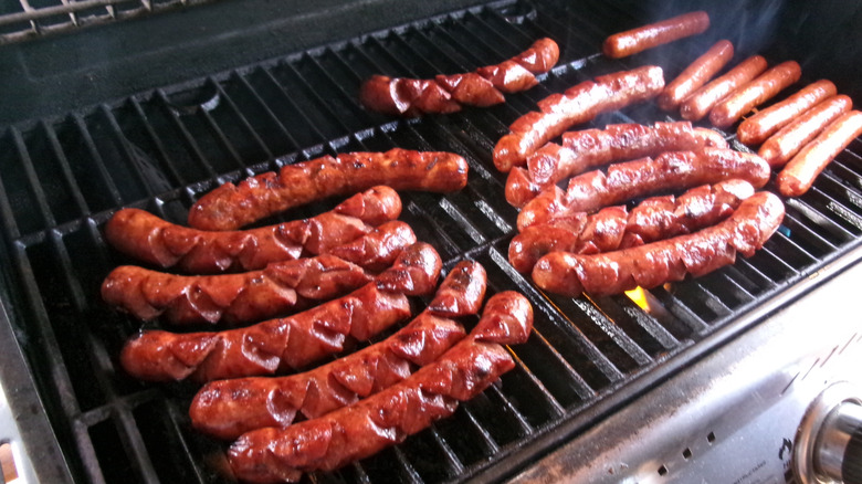 Lots of hot dogs cooking on large grill