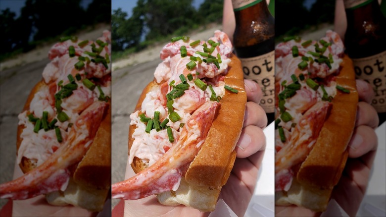 Freshly served lobster roll held in hand