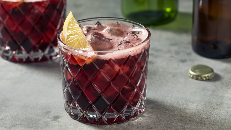 Kalimotxo cocktail with lemon wedge in rocks glass