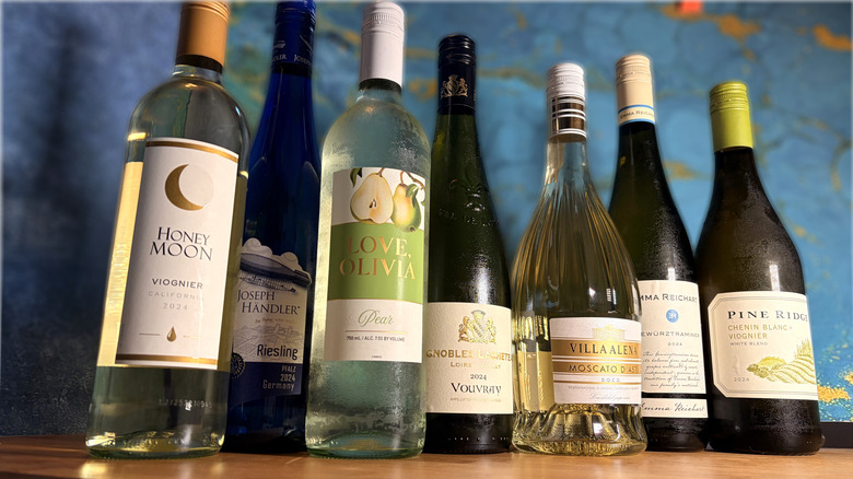 Lined up bottles of white wine on a table