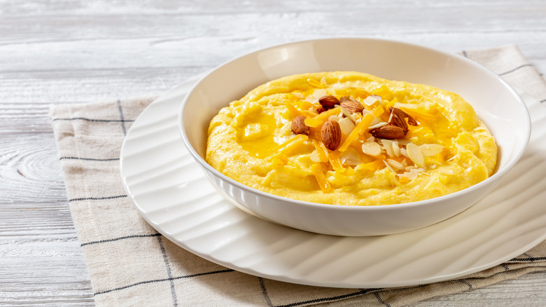 Bowl of grits with shredded cheese and almonds