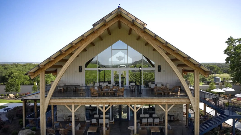 The front of the Augusta Vin winery tasting room building with patio tables