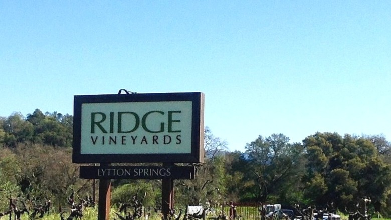 A sign for Ridge Vineyards in the vineyard itself, with a mountain vista in the background
