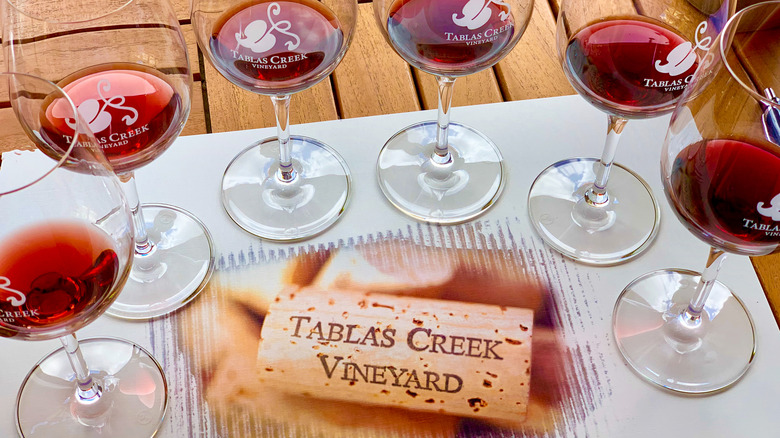 Several glasses of red wine on a table with a Tablas Creek Vineyard cork