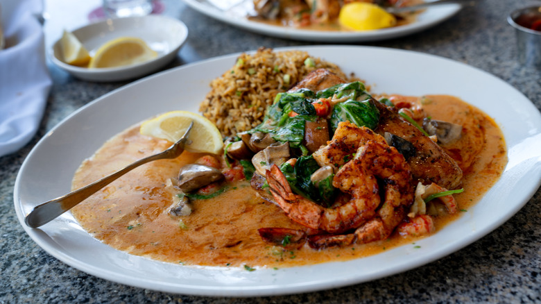 A Cajun-style seafood dish on a table with other dishes