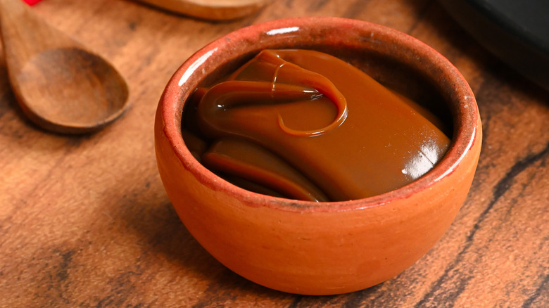 A bowl full of Dulce de Leche on a wooden table