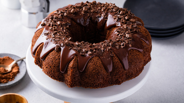 A chocolate bundt cake topped with ganache drizzle