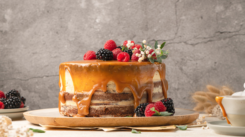 A cake topped with caramel sauce and berries on a plate