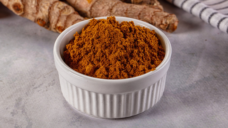 A white bowl full of curry powder on a table