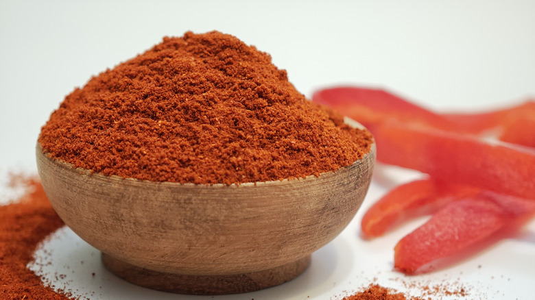 Smoked paprika in a wooden bowl on a white table