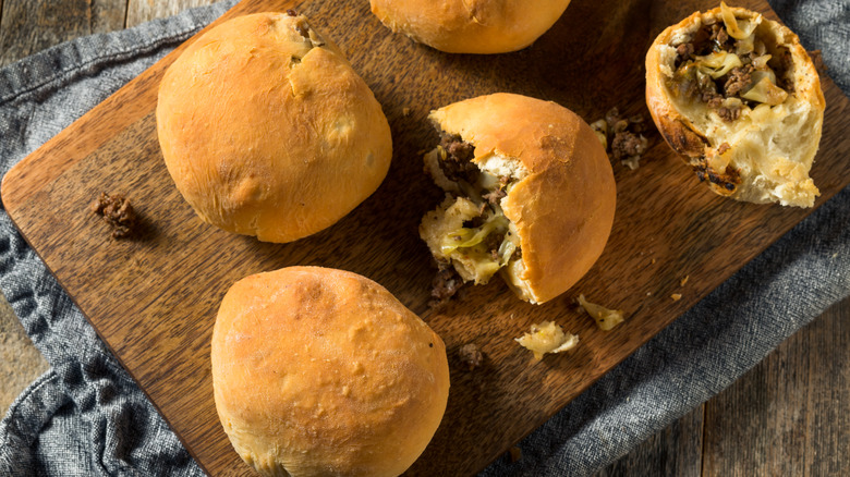 bierocks on a wooden board, whole and split