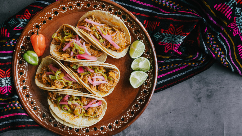 Tacos with wedges of lime and chili peppers
