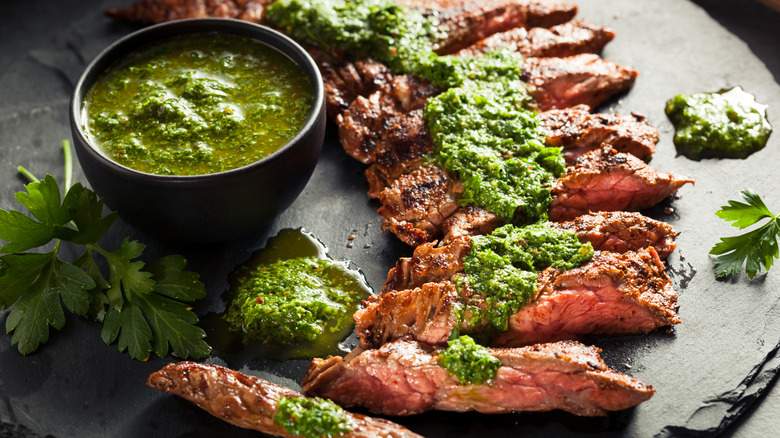 Cooked skirt steak with chimichurri and spices on a plate