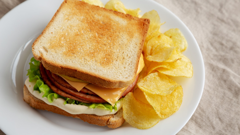 Fried bologna sandwich with chips on a plate