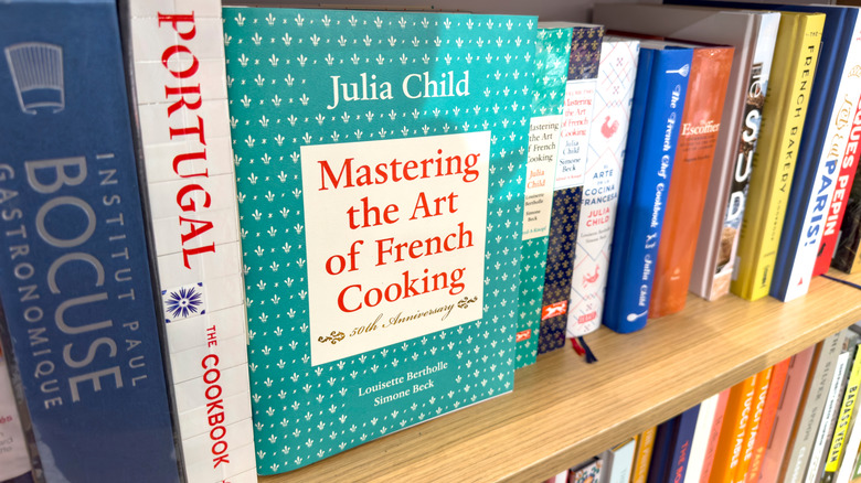 Mastering the Art of French Cooking book on shelf with other cookbooks