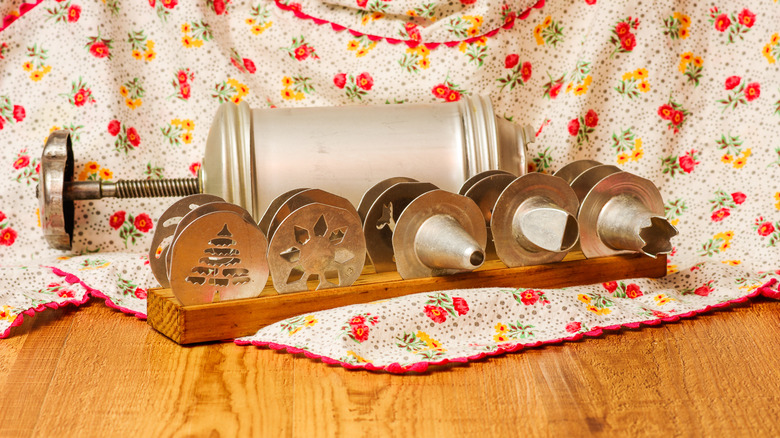 Vintage cookie press with an apron in the background