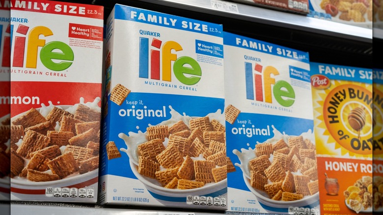 Two boxes of original Life Cereal on a store shelf, in-between boxes of another flavor of Life Cereal and Honey Bunches of Oats