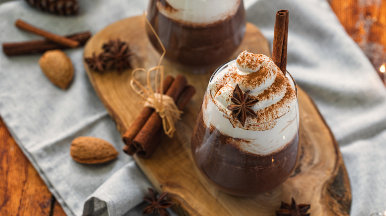 fancy hot chocolate with cinnamon stick on a board