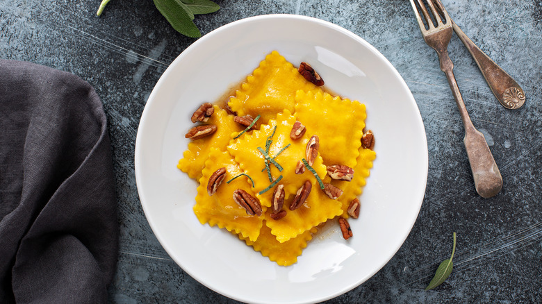 Ravioli with brown butter squash with pecans and sage on slate countertop