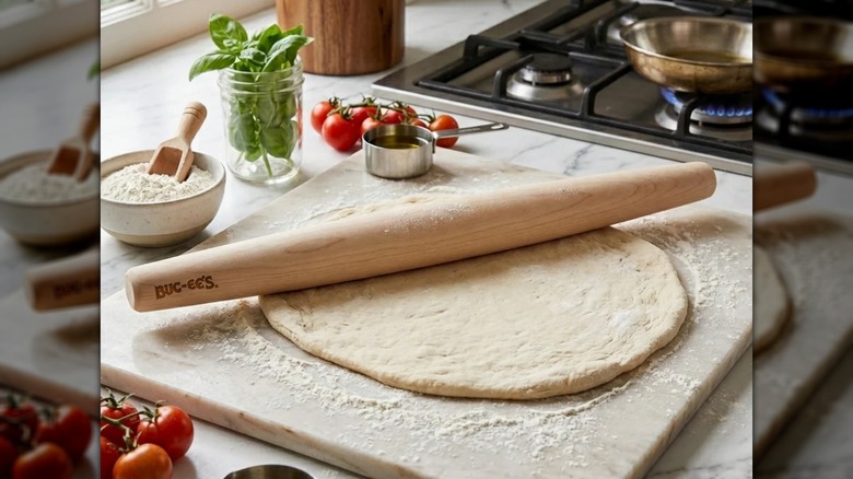 Buc-ee's maple wood tapered rolling pin sitting on top of raw pizza dough