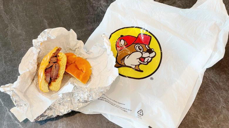 Buc-ee's sliced brisket sandwich sitting in its foil over a Buc-ee's plastic bag