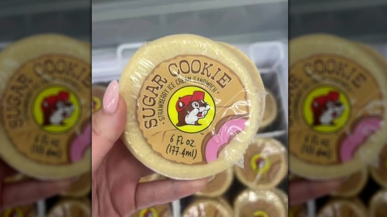 A hand holding a Buc-ee's sugar cookie ice cream sandwich