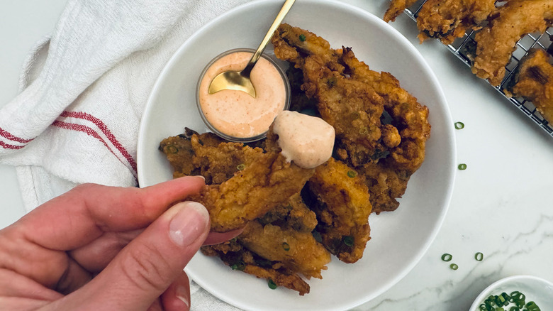 holding fried mushroom with dipping sauce