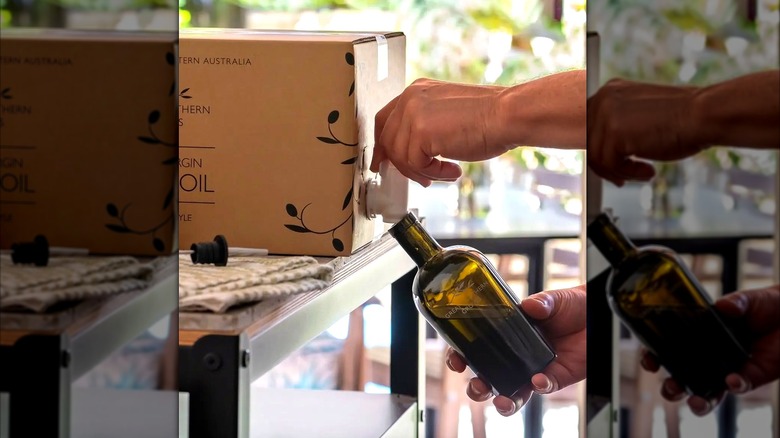 Pouring olive oil from a box tap into a bottle