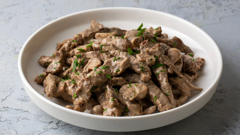 Beef Stroganoff in a white plate placed on a marble table