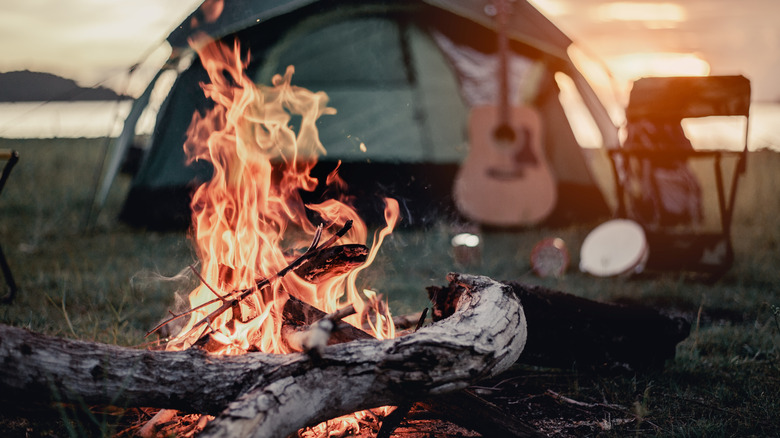 campfire near tent and guitar