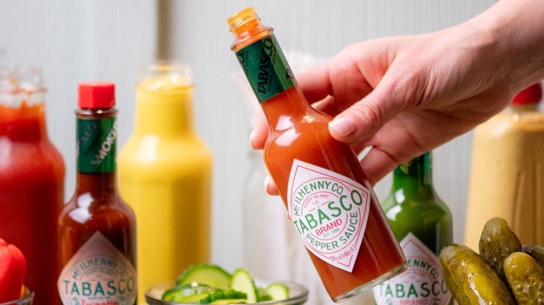 Person holding open bottle of Tabasco 