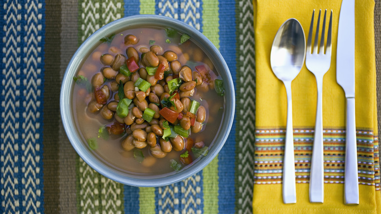 Bowl of beans beside cutlery