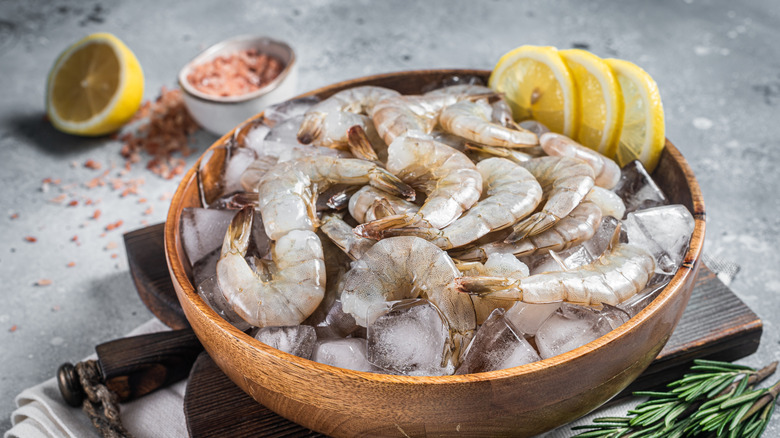 Bowl of traditional Mexican shrimp ceviche with serrano peppers and tomatoes on a wood table with red cloth