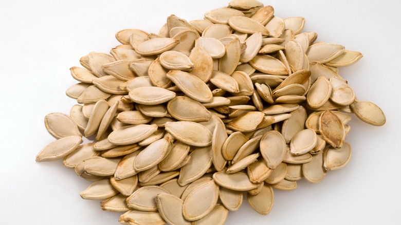 Whole pumpkin seeds on white background