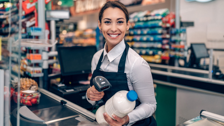 Grocery store employee scanning milk