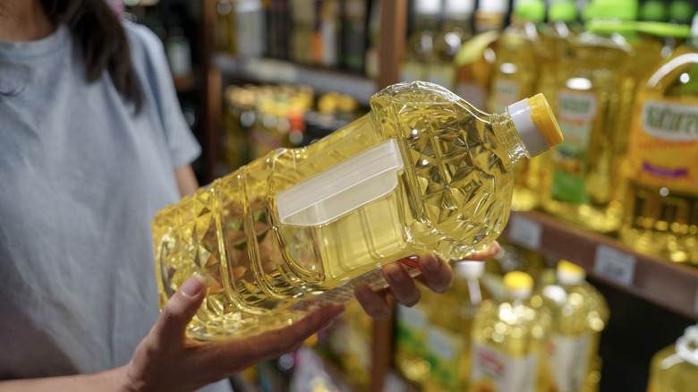 Shopper holding a large bottle of cooking oil
