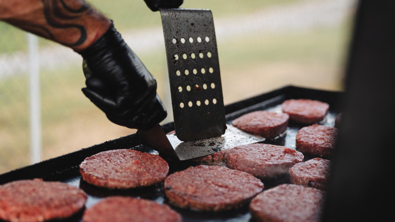 Flipping burgers on a flat-top griddle