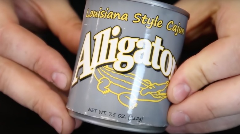 hands holding can of alligator meat