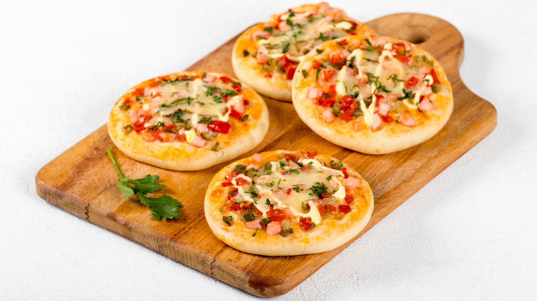 mini pizzas on wooden cutting board
