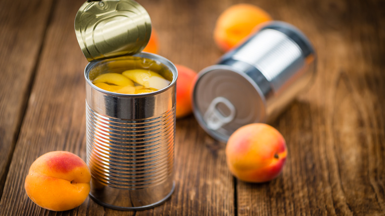 Canned peaches on wood surface 