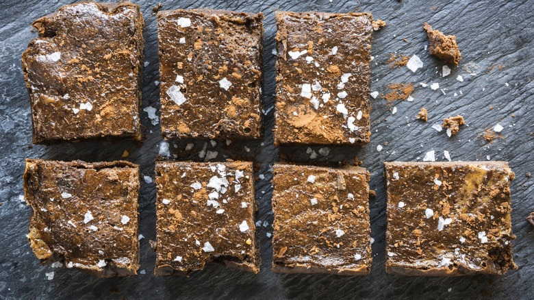 Sliced and salted brownies on a gray stone surface