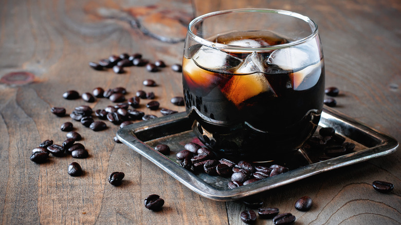 Black Russian cocktail surrounded by coffee beans 