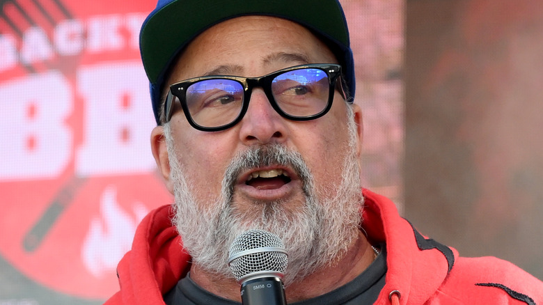 Andrew Zimmern speaking into microphone