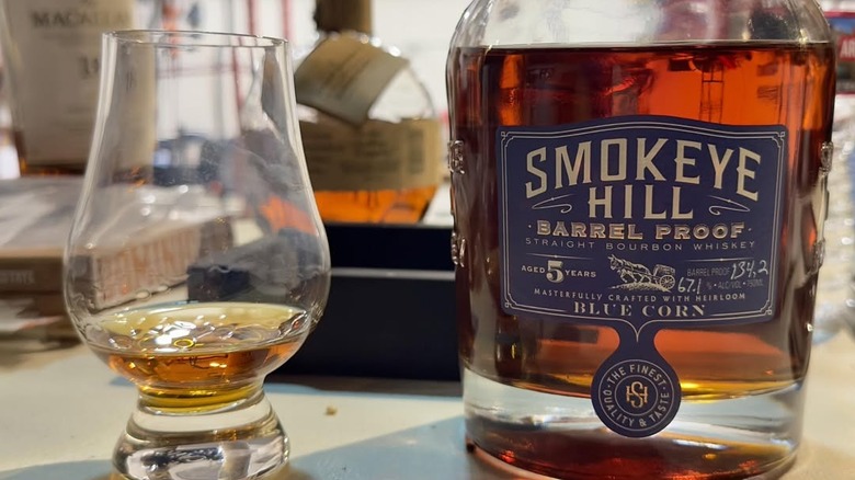 Glass of bourbon on wooden plate