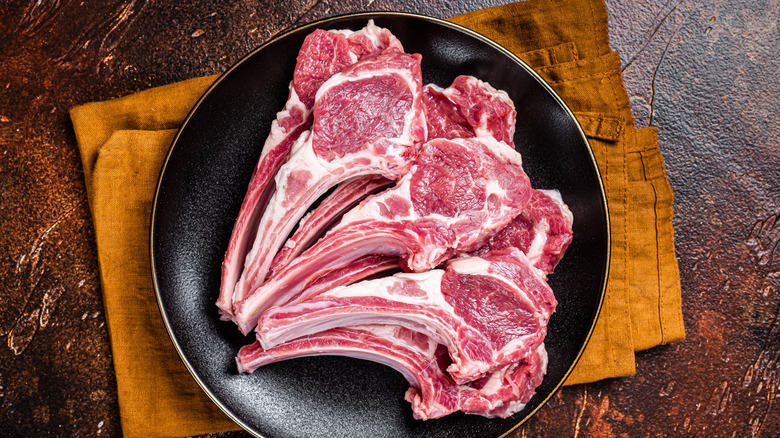 Raw lamb chops on a rustic plate