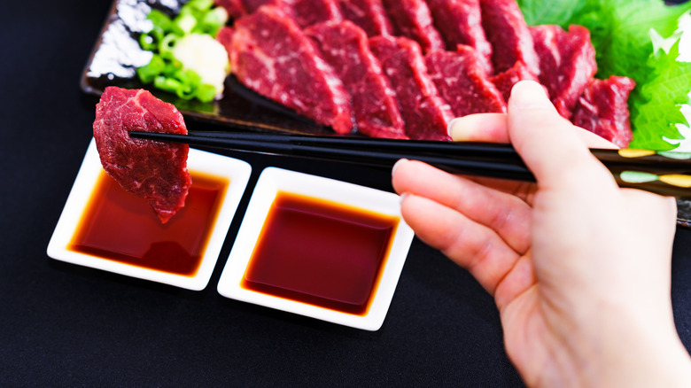 dipping basashi in soy sauce