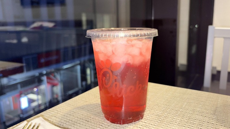 A closeup on a Strawberry Hibiscus Sprite from chick-fil-a on a table