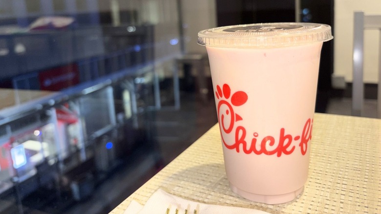 A closeup on a light pink Strawberry Hibiscus Frosted Lemonade from chick-fil-a on a table